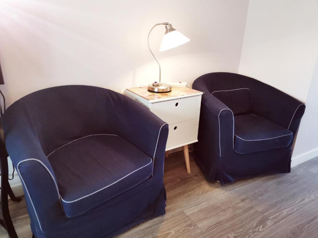 two chairs and a table with a lamp on a side table at Bed Plus YVR in Richmond