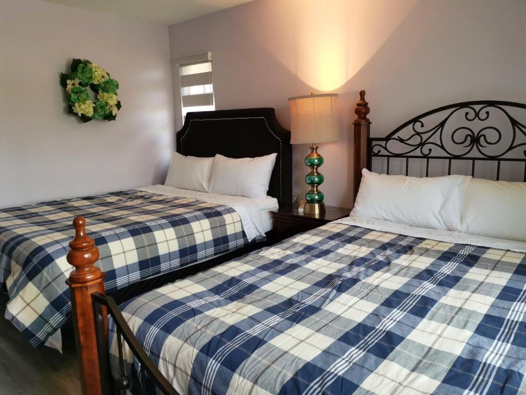two beds sitting next to each other in a bedroom at Bed Plus YVR in Richmond
