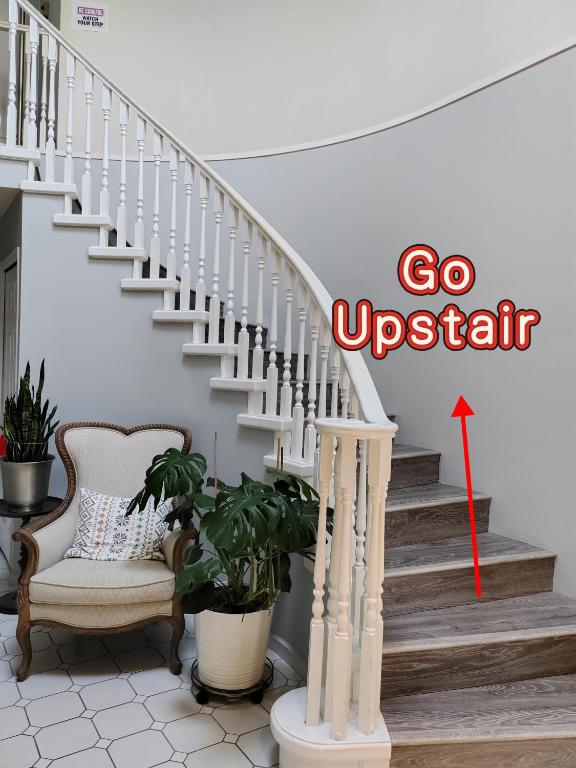 a stairway with a red arrow pointing to go upstairs at Bed Plus YVR in Richmond