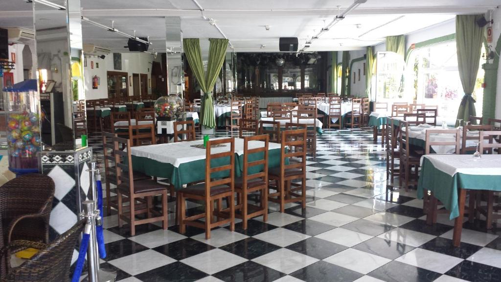restauracja ze stołami i krzesłami oraz podłogą wyłożoną szachownicą w obiekcie Alojamiento Jose Carlos w Maladze