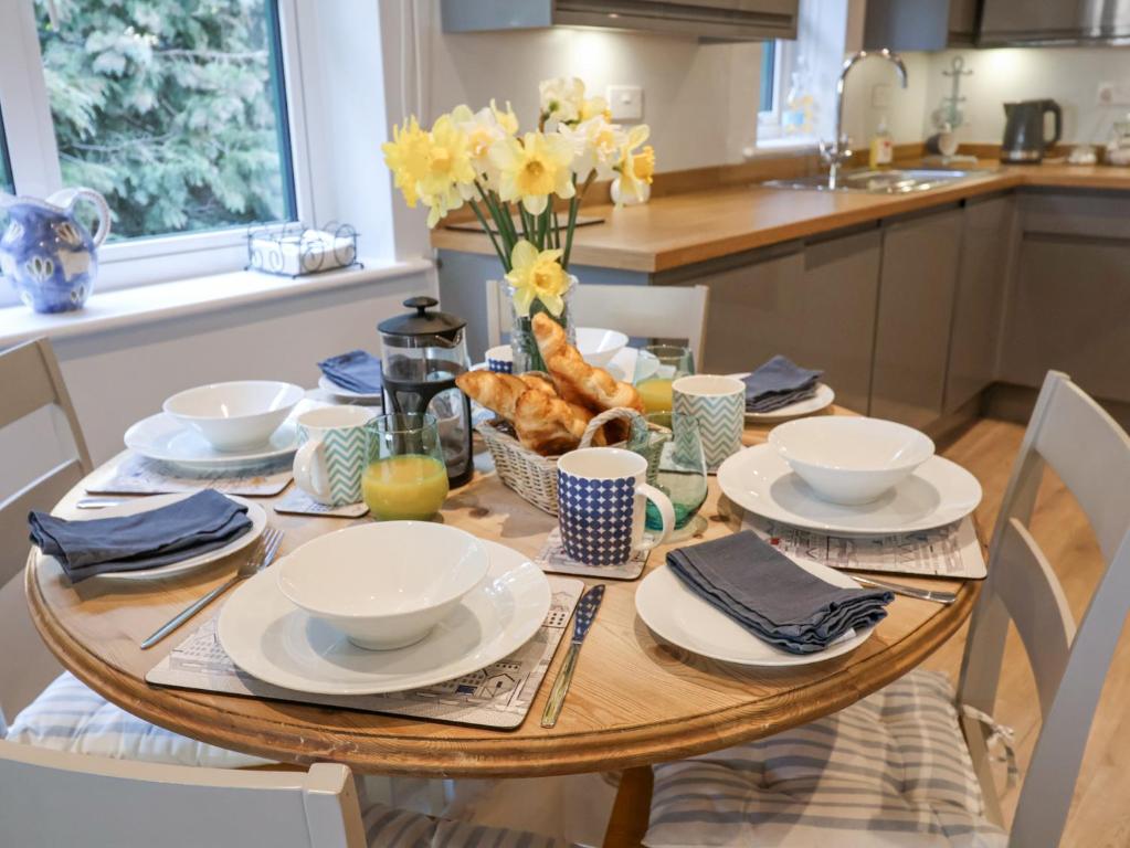 a wooden table with dishes and flowers on it in a kitchen at Bradley's Barn in Colchester