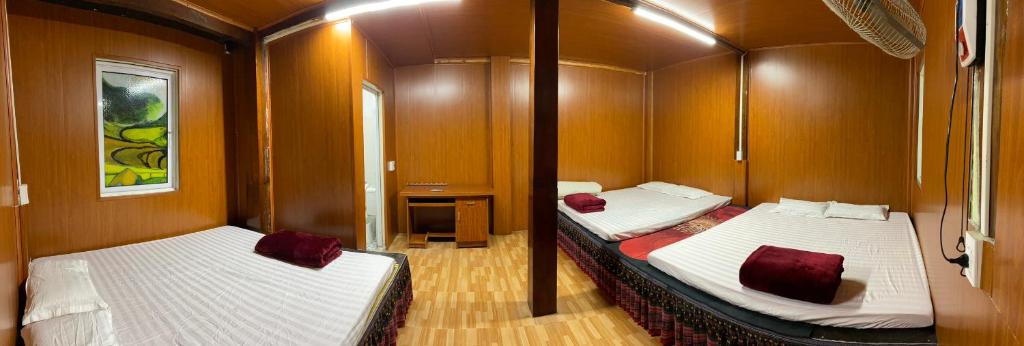 a room with two beds in a cabin at Cô gái thái Homestay in Mù Cang Chải