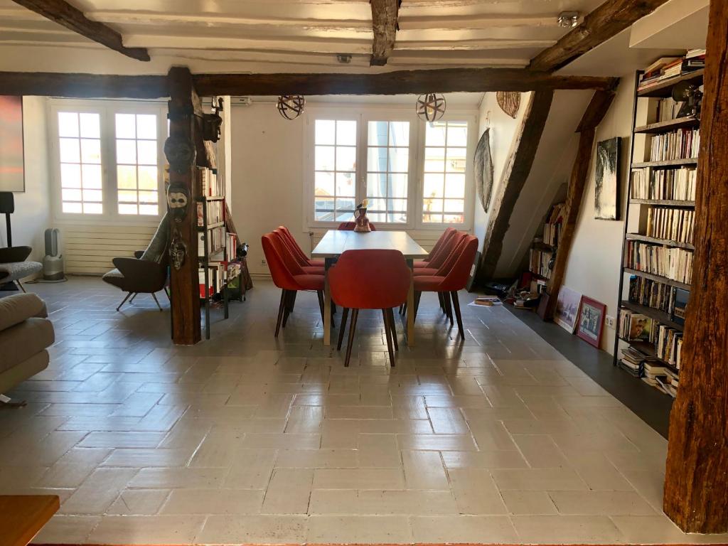 une salle à manger avec une table et des chaises rouges dans l'établissement Luxurious loft in Le Marais, à Paris