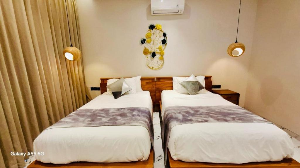 two beds in a small room with curtains at Vila Cartenz in Jimbaran