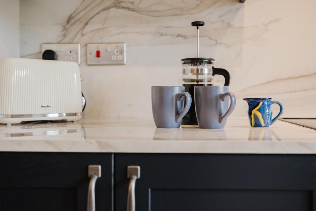 a kitchen counter with two cups and a blender at Country Cottage in the Heart of the Cotswolds! in Farmington