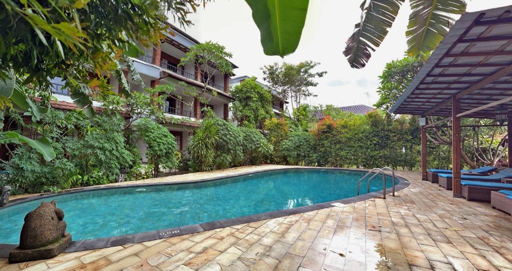 a swimming pool in front of a building at Sanur Lodge in Sanur