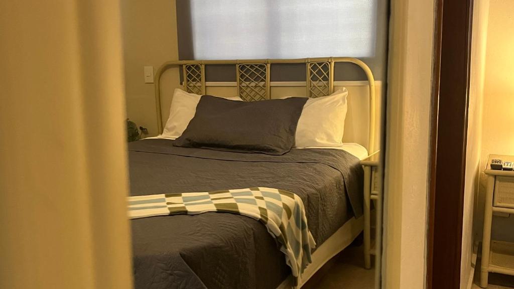 a bedroom with a bed with a metal headboard at Hotel Plaza Kavia in Santo Domingo