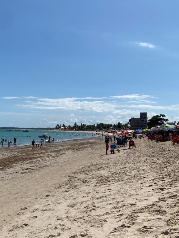 a group of people on a beach with the ocean at Flat na beira-mar de Tamandaré in Tamandaré