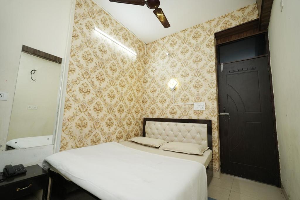 a bedroom with a bed and a mirror and a door at Swagat Guest House in Dehradun