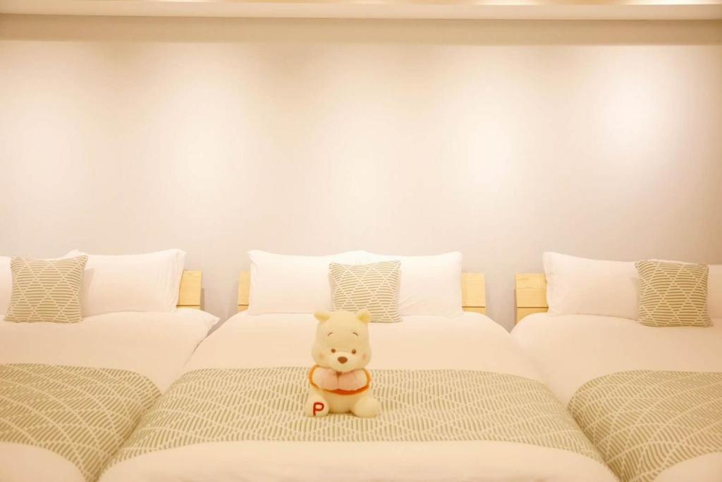 zwei Betten mit einem Teddybären zwischen ihnen in der Unterkunft 森下小屋 in Tokio