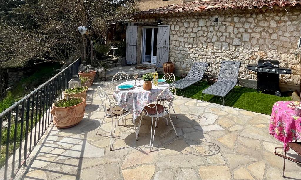 a patio with a table and chairs and a house at La maison d'Eddy et Caro aux Portes du Verdon in Trigance
