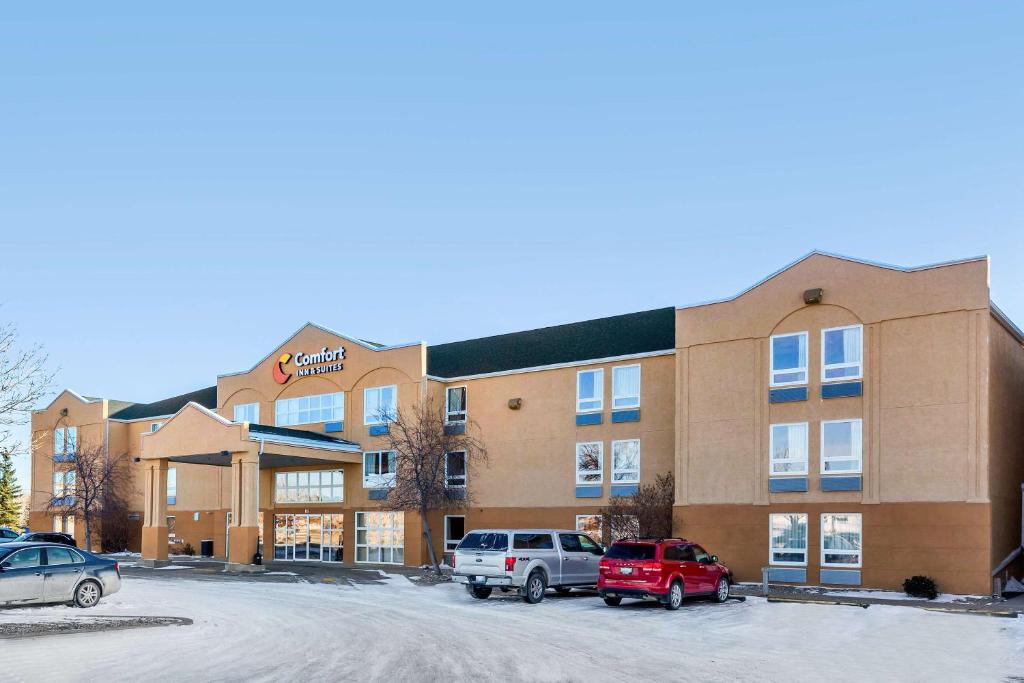 Un hotel con coches aparcados en un estacionamiento. en Comfort Inn &amp; Suites, en Moose Jaw