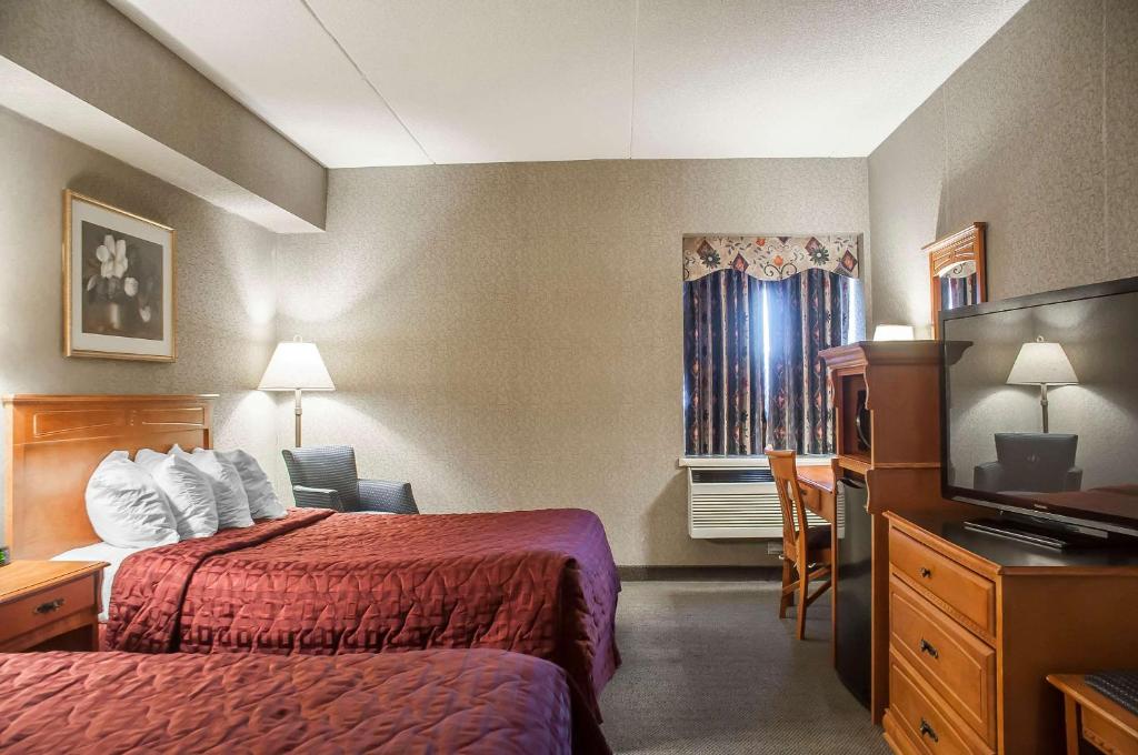 a hotel room with a bed and a television at Comfort Inn Lundy's Lane in Niagara Falls