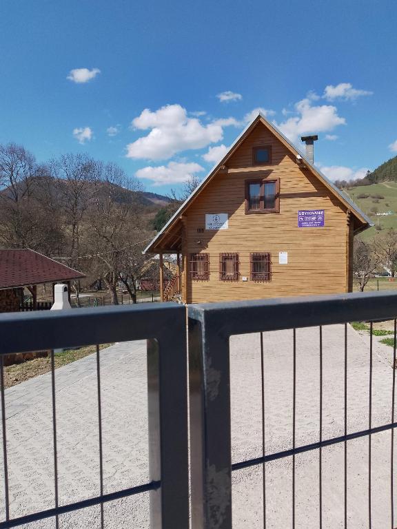 a wooden house with a gate in front of it at Komposesorátny dom Kalameny in Kalameny