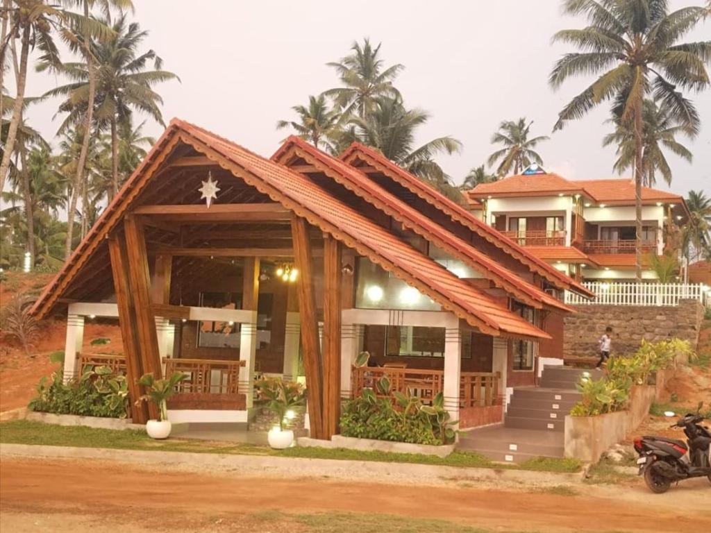 a house with a roof with palm trees at Flower Hill Cottage in Varkala
