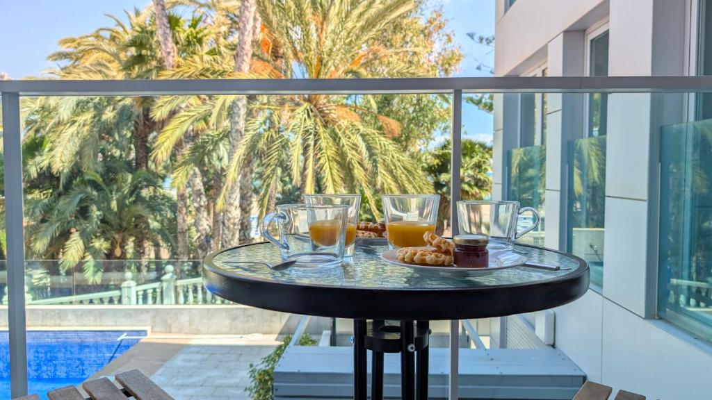 einen Tisch mit Gläsern und einen Teller Essen auf dem Balkon in der Unterkunft MIRADOR lovely apartment in Benidorm