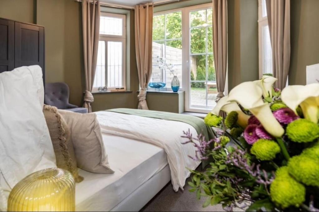 un dormitorio con una cama con un ramo de flores en Jonica ApartHotel, en Bremen