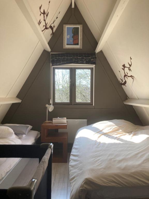 a attic room with two beds and a window at Chalet Séquoia 138 Nature, piscine et chien bienvenu à Durbuy in Durbuy