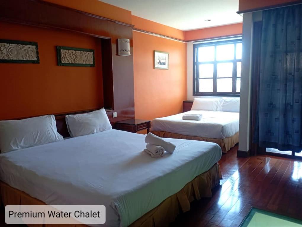 a hotel room with two beds and a window at Alpine Premium Water Chalet 2 in Port Dickson