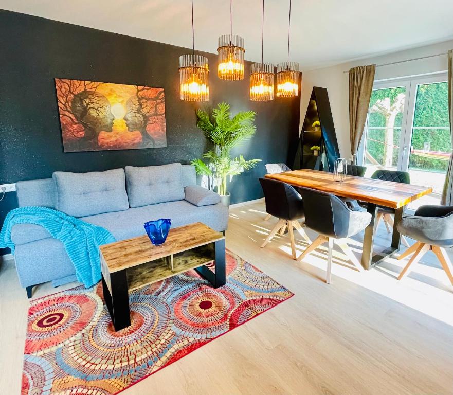 a living room with a couch and a table at The Villa Toscana, a serene retreat in Center of Friedrichshafen City with lush green lawns, terrace & private garage- Lidl, Bakery walking distance- Bodenseecenter, Sportsbad 3 mins, Lake 7 mins in Friedrichshafen