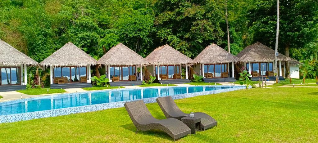 un resort con piscina con sedie e capanne di Bebeladan Beach Eco-Resort, The Last Indigenous Corner a El Nido