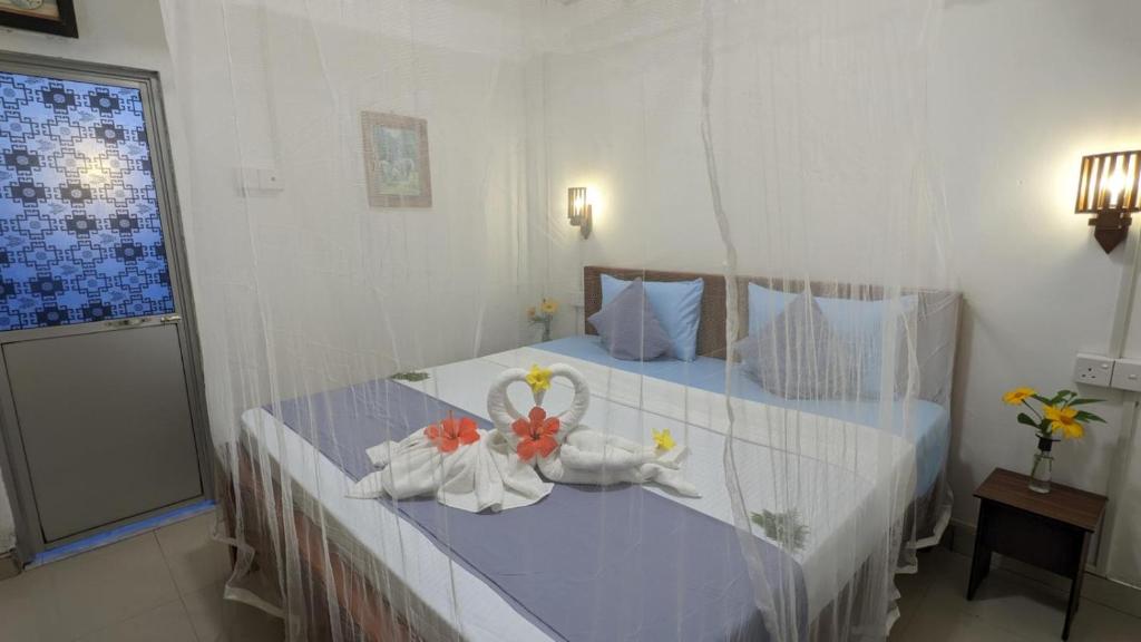 um quarto com uma cama com toalhas em Shenahi Homestay Hiriketiya em Dikwella