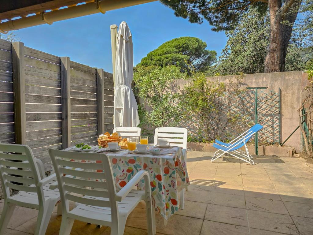 - une table avec un parasol et des chaises sur la terrasse dans l'établissement Le Mazet à la mer WiFi Clim Parking, à Cavalaire-sur-Mer