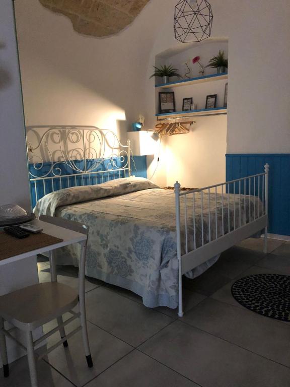 a bedroom with a bed with a table and a chair at casa Pavone in Monopoli