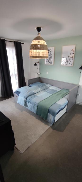 - une chambre avec un grand lit et un lustre dans l'établissement l'incontournable Villepinte Parc des expositions, à Villepinte