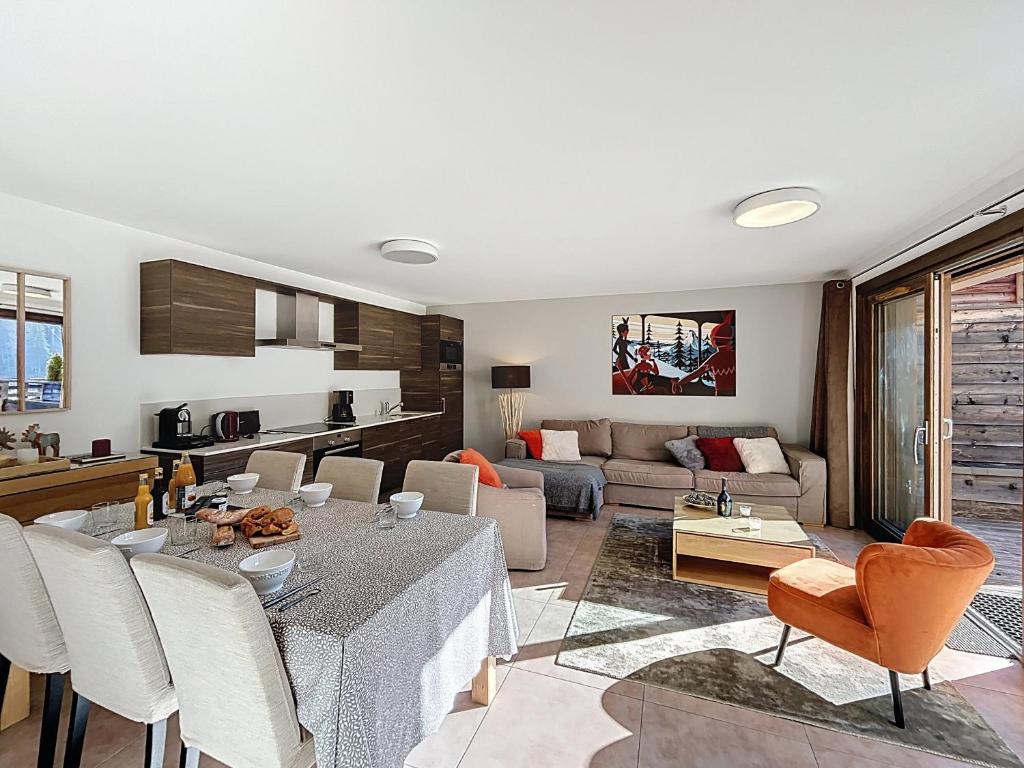 une cuisine et un salon avec une table et des chaises dans l'établissement Charme-appartement-6 pers-proche piste, aux Gets