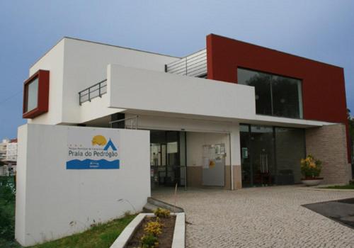 a building with a sign in front of it at Parque de Campismo da Praia de Pedrogao in Coimbrão