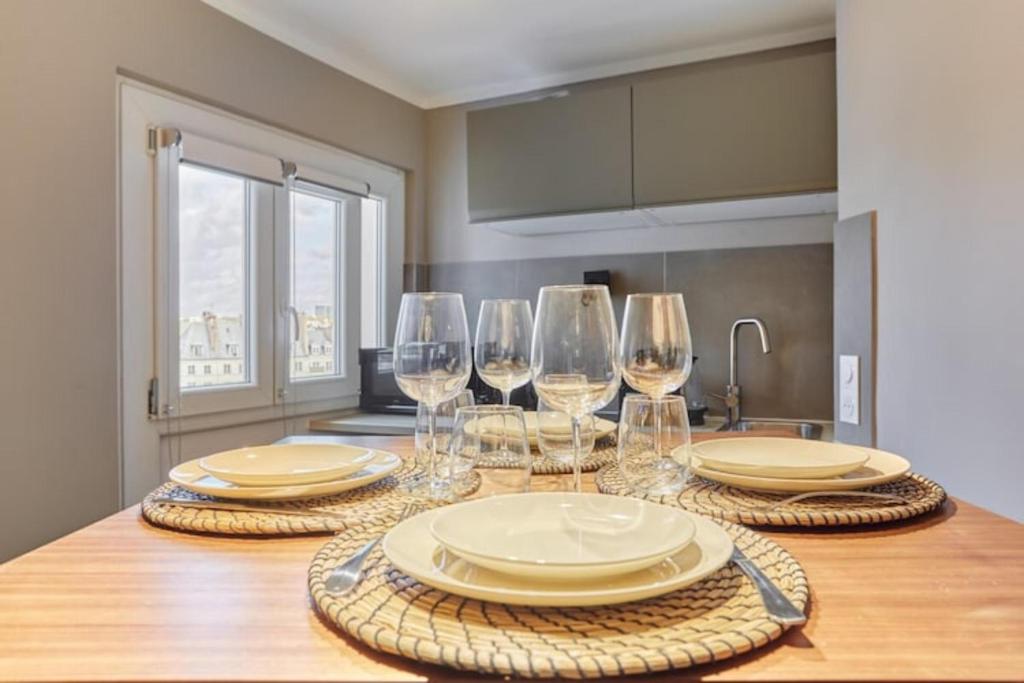 une cuisine avec une table avec des assiettes et des verres à vin dans l'établissement Apartment Centre de Paris Le Marais, à Paris