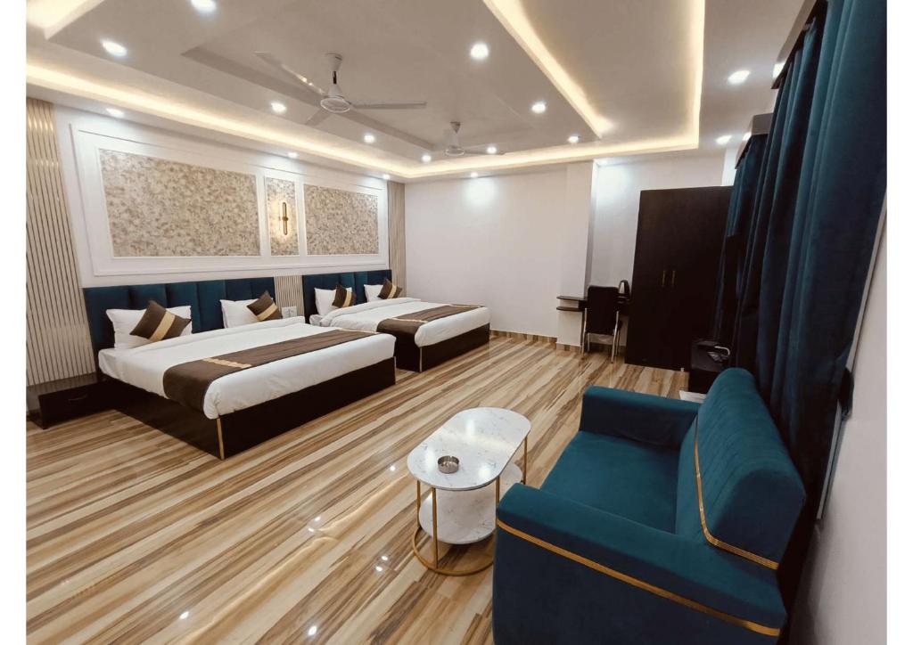 a hotel room with two beds and a couch at Celestial Inn in Prayagraj