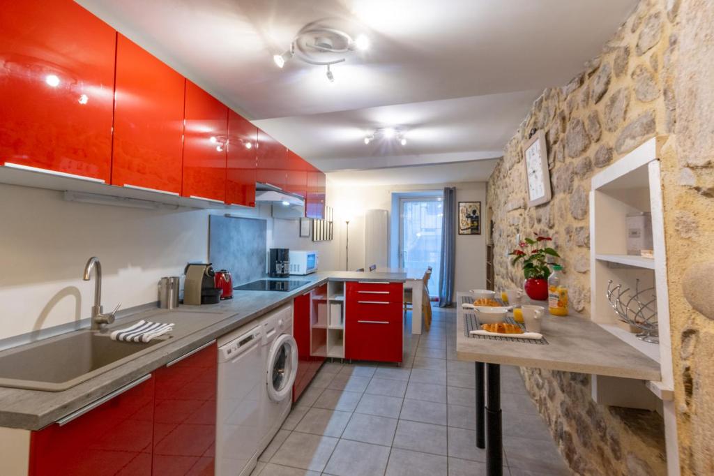 une cuisine avec des armoires rouges et un évier dans l'établissement Charmant T2 Centre historique, à Vals-les-Bains