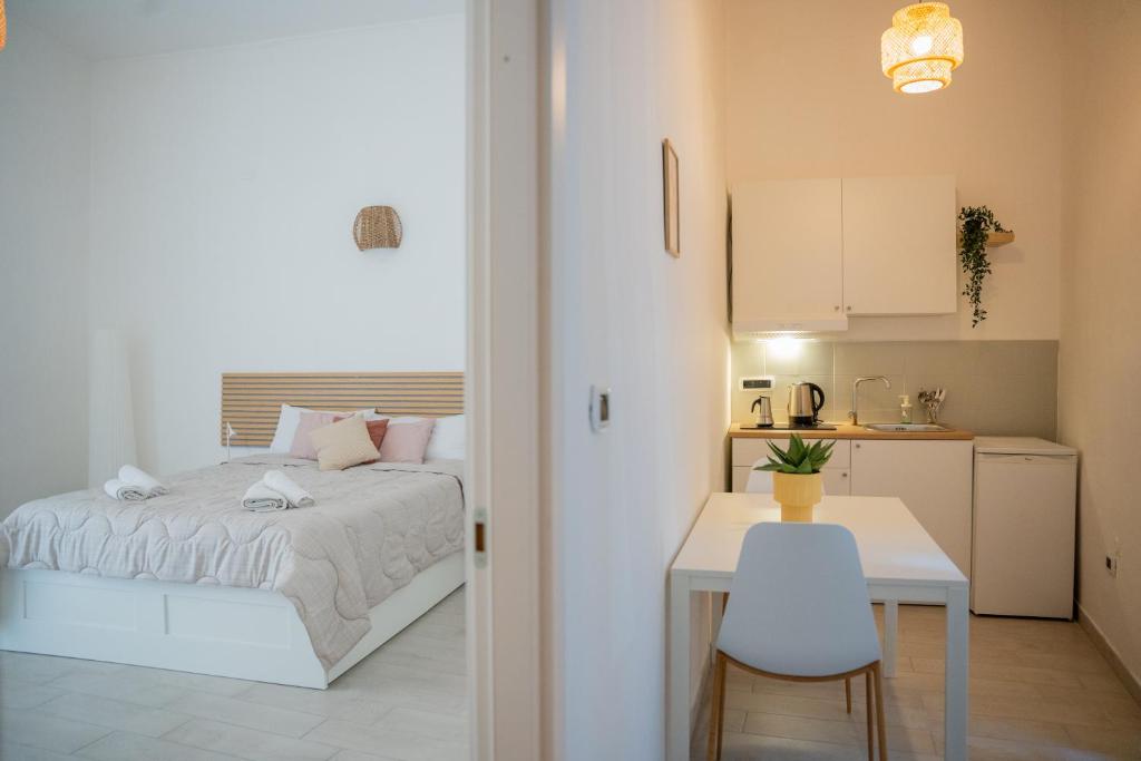 a bedroom with a bed and a table and a kitchen at Cozy Historical Nest in Naples
