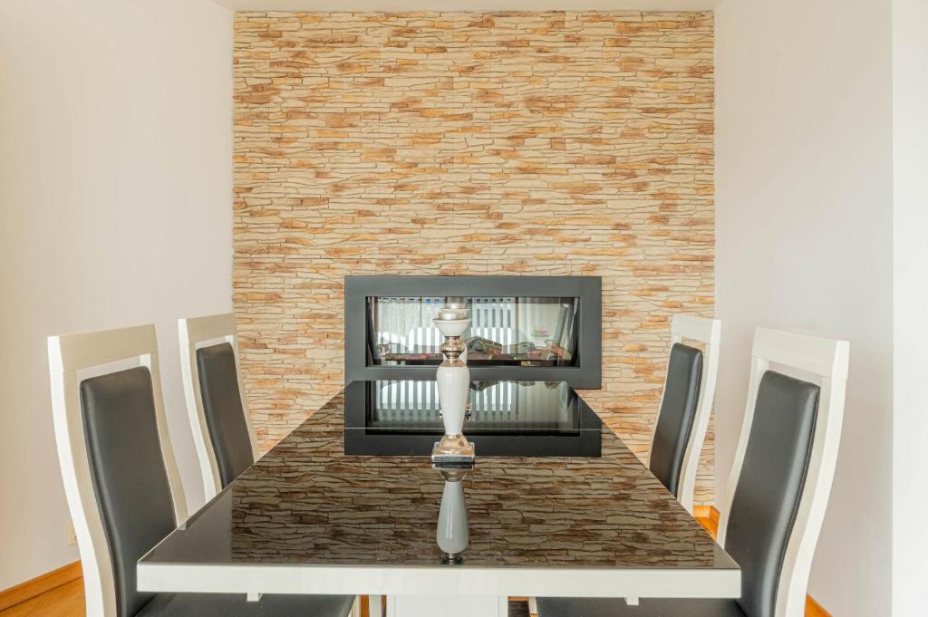 a dining room table with a brick fireplace at Horyzont Apartamenty- Apartament Nadmorski, blisko PKP i centrum in Kołobrzeg