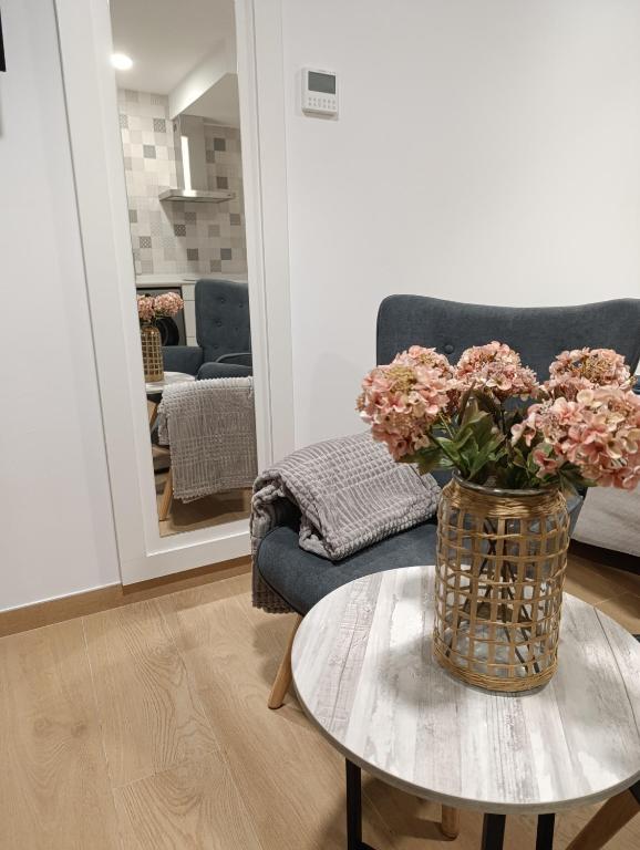 a living room with a vase of flowers on a table at Vaiche Boa! in Corcubión