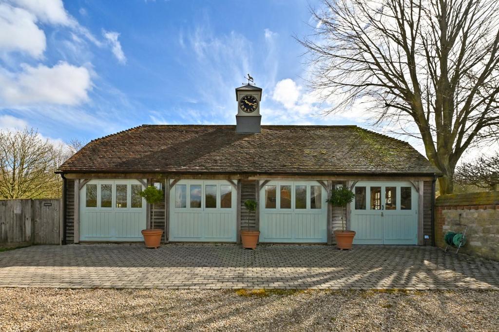 a garage with a clock tower on top of it at Idyllic Cottage in South Oxfordshire in Chalgrove