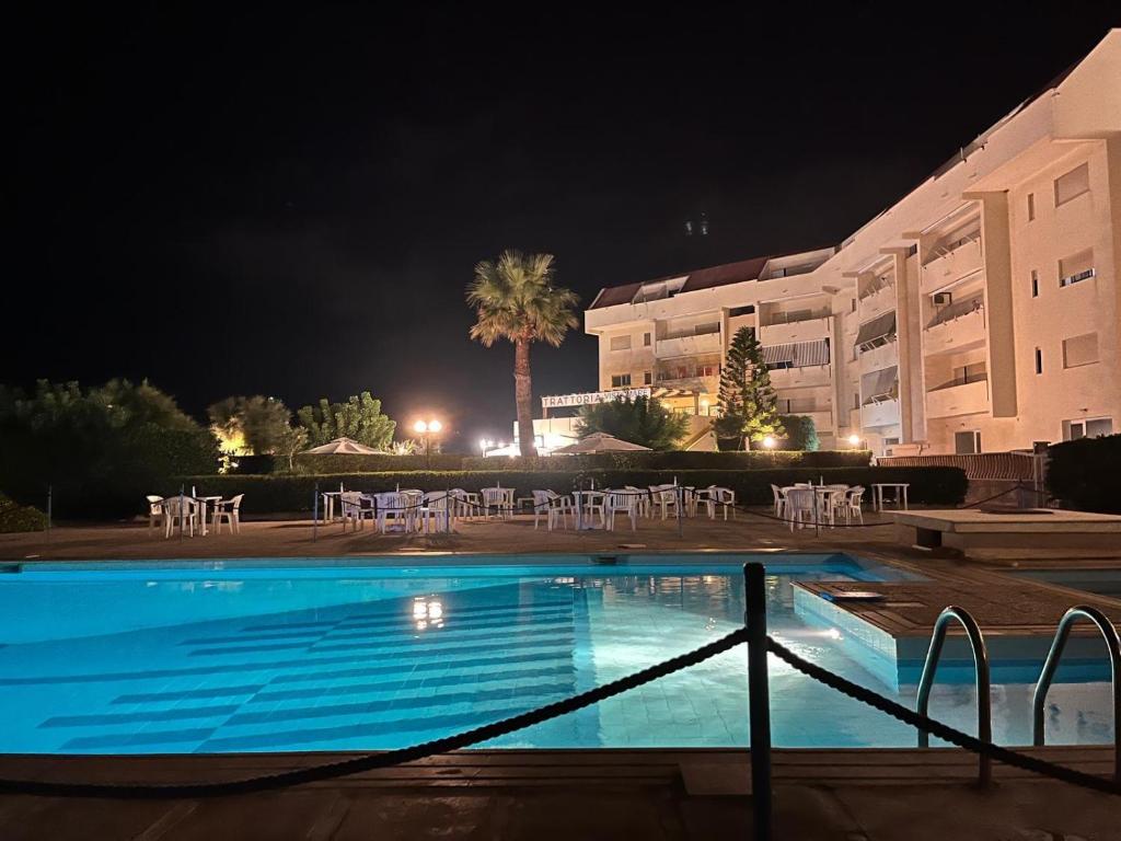 Una piscina frente a un hotel por la noche. en CASADAMARE Erice Beach, en Erice