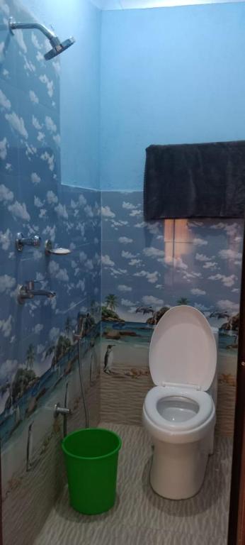 baño con aseo y un mural de nubes en KharidhugaHotel and lodge, en Rāmechhāp