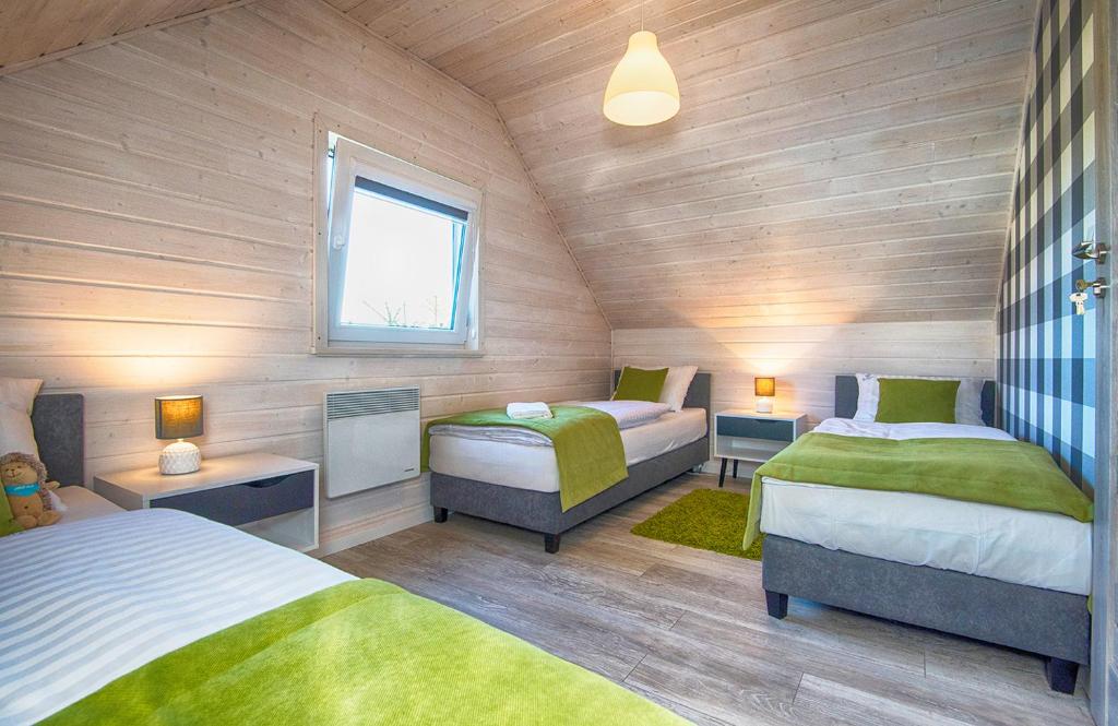 una camera da letto con due letti e una finestra di FLAUTA Całoroczne domki z prywatną balią, sauną i jacuzzi a Sianozety
