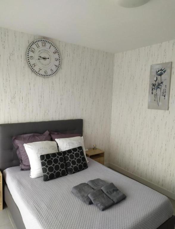 - une chambre dotée d'un lit avec une horloge murale dans l'établissement studio 127, à Sens
