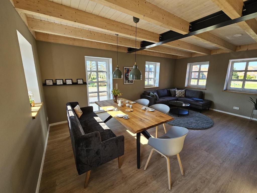 a living room with a wooden table and a couch at Ferienhaus Mühle 7 in Krummhörn