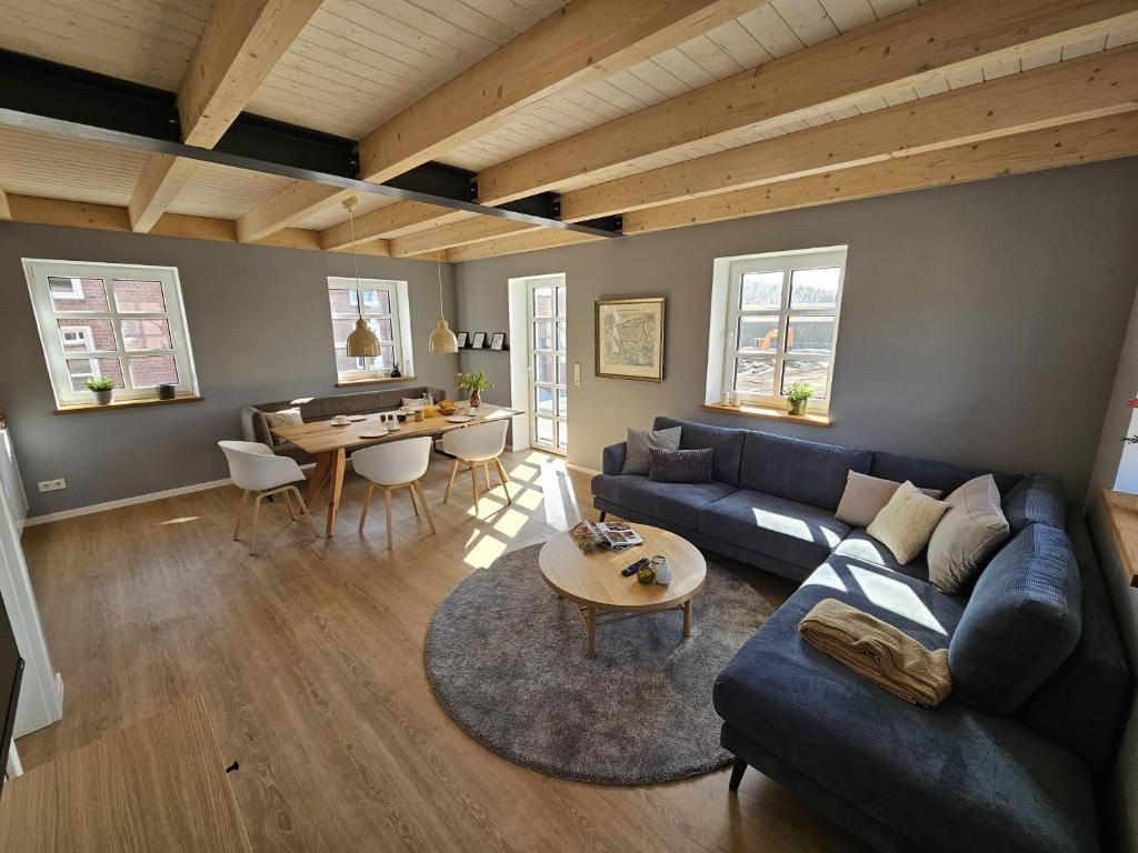 a living room with a blue couch and a table at Ferienhaus Mühle 5 in Krummhörn