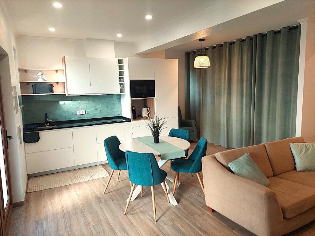 ein Wohnzimmer mit einer Couch und einem Tisch und Stühlen in der Unterkunft Apartment Studio Espiche near Praia da Luz in Luz