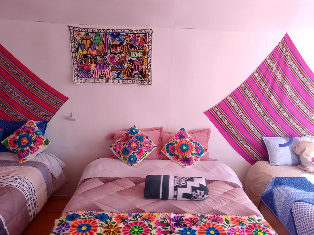 a room with two beds and a picture on the wall at Wiñay UTA lodge in Puno