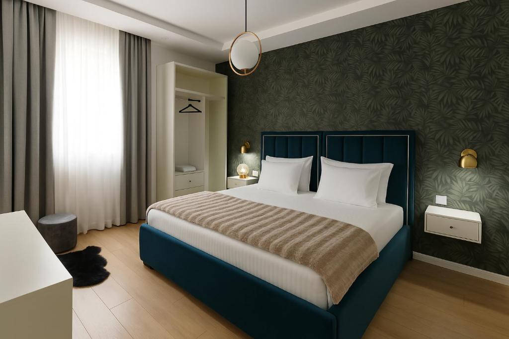 a bedroom with a large bed with white pillows at Hotel Capital Inn Tirana in Tirana
