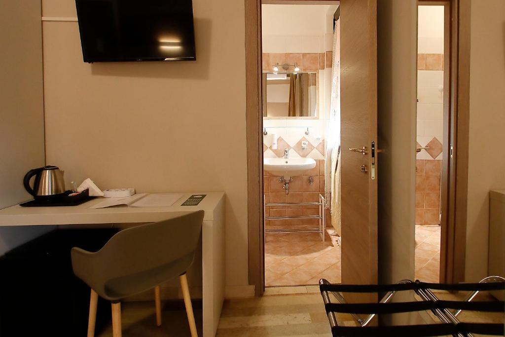 a kitchen with a sink and a table and a bathroom at Hotel Primavera in Peschiera del Garda
