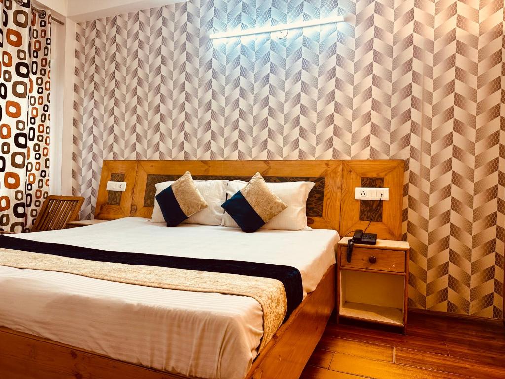 a bedroom with a large bed with a wooden headboard at Village House Manali in Manāli