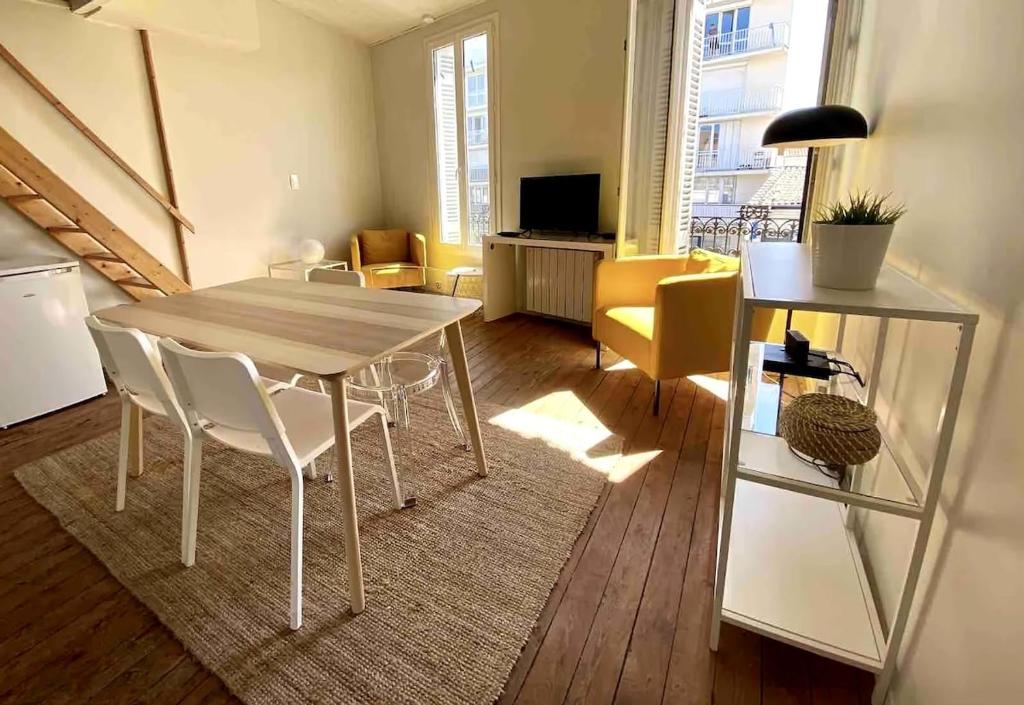 un salon avec une table et des chaises de salle à manger dans l'établissement Charming T2 apartment 200 m from tram B, à Talence